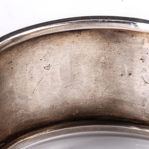 298 - A Victorian unmarked silver hinged cuff bangle, engraved leaf decoration with inscription dated 1882... 