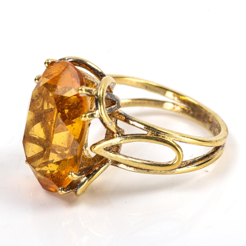 306 - A late 20th century citrine dress ring, unmarked yellow metal openwork settings, citrine length 18mm... 