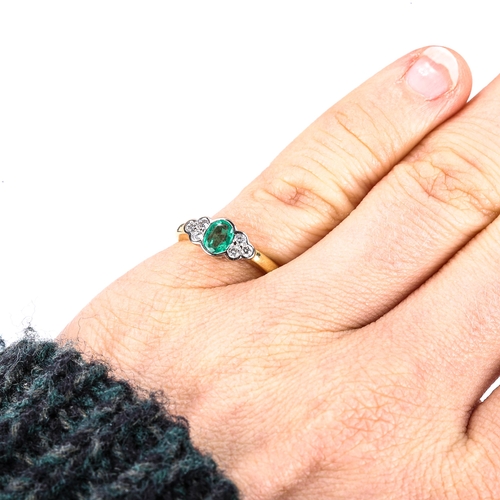 366 - A modern 18ct gold emerald and diamond dress ring, set with oval mixed-cut emerald and modern round ... 