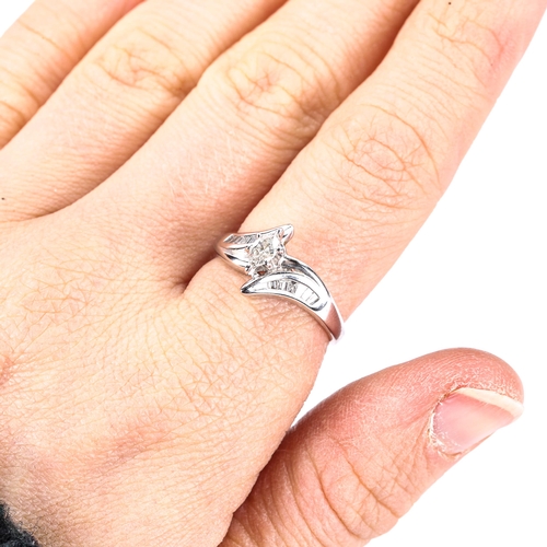 374 - A modern 14ct white gold marquise diamond solitaire ring, with crossover style baguette-cut diamond ... 