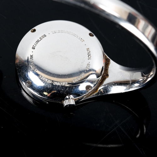 394 - GEORG JENSEN - a Danish stainless steel quartz bangle watch, designed by Vivianna Torun Bulow-Hube, ... 