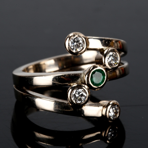 403 - A large and heavy modern 18ct white gold emerald and diamond crossover ring, set with round-cut emer... 