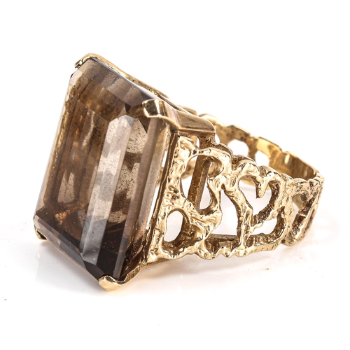 405 - A large Vintage 9ct gold smoky quartz dress ring, pierced and textured organic design shoulders with... 