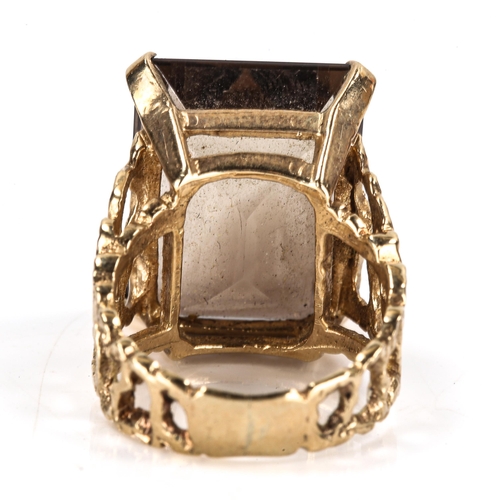 405 - A large Vintage 9ct gold smoky quartz dress ring, pierced and textured organic design shoulders with... 