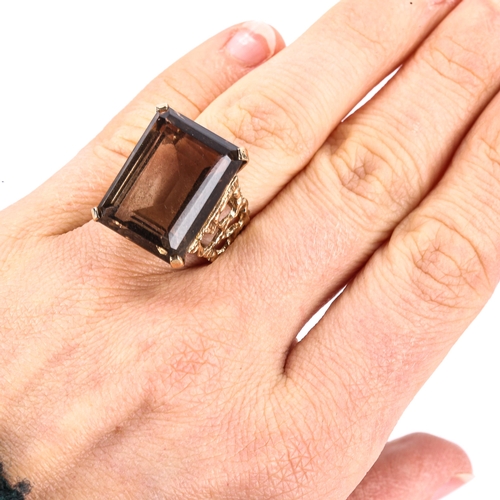 405 - A large Vintage 9ct gold smoky quartz dress ring, pierced and textured organic design shoulders with... 