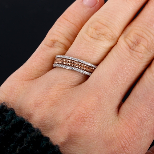 414 - A modern 9ct white and rose gold diamond half eternity ring, openwork rope twist centre flanked by r... 