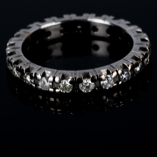 415 - An unmarked white gold diamond eternity ring, set with modern round brilliant-cut diamonds, total di... 