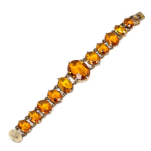 423 - An Edwardian graduated citrine line bracelet, unmarked white metal settings with oval mixed-cut citr... 