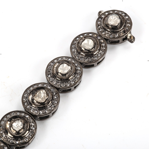 451 - A modern unmarked oxidised silver diamond cluster bracelet, set with table and rose-cut diamonds, to... 