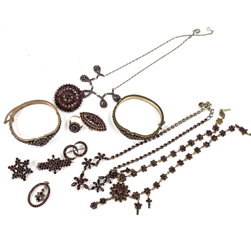 453 - A large group of Bohemian garnet jewellery, including hinged bangles, pendants, brooches, necklaces ... 