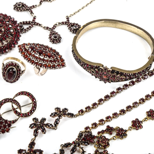 453 - A large group of Bohemian garnet jewellery, including hinged bangles, pendants, brooches, necklaces ... 