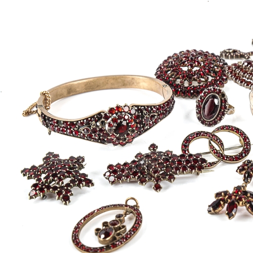 453 - A large group of Bohemian garnet jewellery, including hinged bangles, pendants, brooches, necklaces ... 