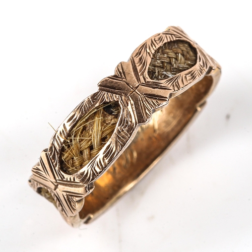 516 - A Victorian 9ct gold woven hair memorial ring, with openwork panels displaying hair with internal in... 