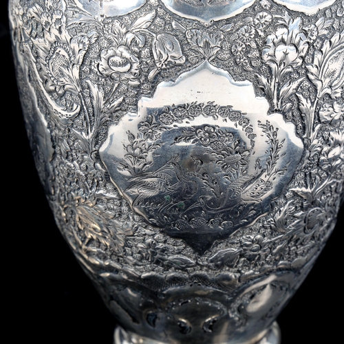 547 - A Persian white metal baluster vase, relief embossed and engraved floral decoration with marks on ne... 