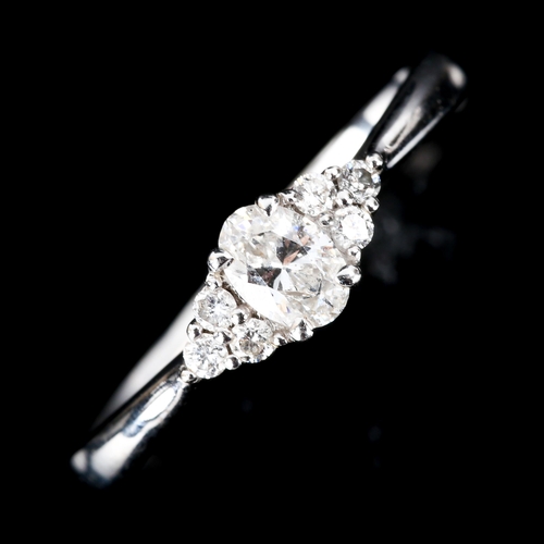 596 - An 18ct gold solitaire diamond ring, set with oval brilliant-cut diamond and modern round brilliant-... 