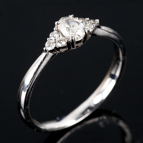 596 - An 18ct gold solitaire diamond ring, set with oval brilliant-cut diamond and modern round brilliant-... 