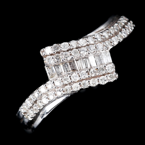 603 - A 9ct white gold diamond cluster crossover ring, set with baguette and round brilliant-cut diamonds,... 