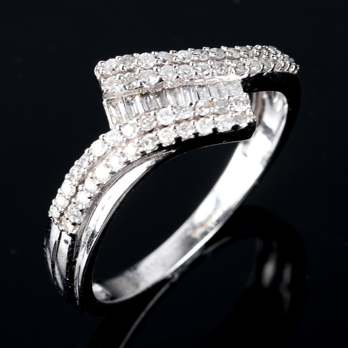 603 - A 9ct white gold diamond cluster crossover ring, set with baguette and round brilliant-cut diamonds,... 