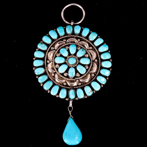 608 - A large Native American Navajo unmarked silver and turquoise pendant, relief embossed decoration wit... 