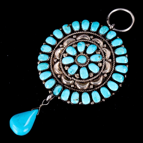 608 - A large Native American Navajo unmarked silver and turquoise pendant, relief embossed decoration wit... 