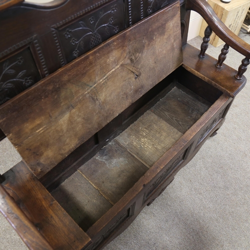 1255 - A 19th century French oak settle, with carved panelled back and rising seat, width 114cm