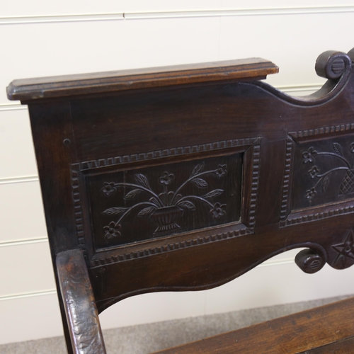 1255 - A 19th century French oak settle, with carved panelled back and rising seat, width 114cm