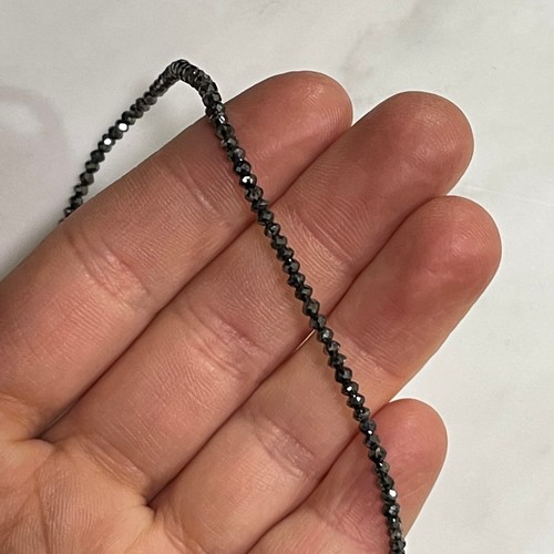 129 - A modern black diamond necklace, set with single-strand of faceted black diamond beads, with 14ct go... 