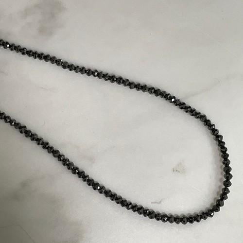 129 - A modern black diamond necklace, set with single-strand of faceted black diamond beads, with 14ct go... 