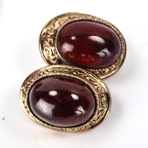 154 - A pair of cabochon garnet cufflinks, unmarked yellow metal settings with engraved foliate border, pa... 