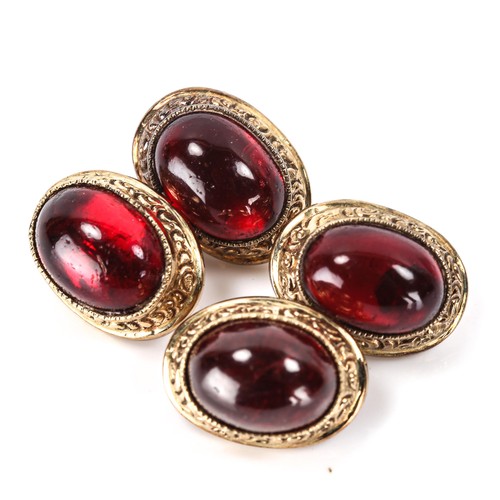 154 - A pair of cabochon garnet cufflinks, unmarked yellow metal settings with engraved foliate border, pa... 