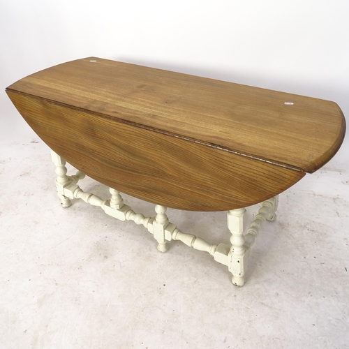 2135 - An Ercol polished and painted drop leaf coffee table, on turned legs, L106cm