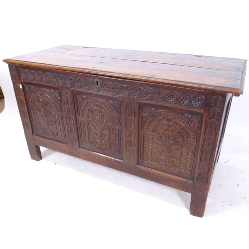 2155 - An 18th century joined oak coffer, with chip carved panelled front on stile legs, W126cm, H68cm, D54... 