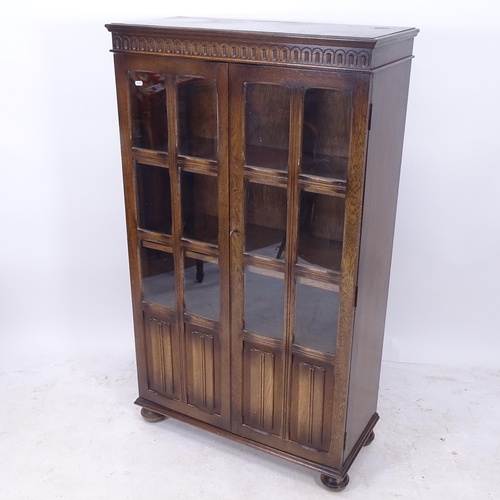 2176 - A linenfold panelled and glazed oak 2-door bookcase, with key, W79cm, H136cm, D35cm (with key)