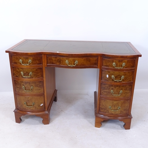 2200 - A reproduction yew wood serpentine-front kneehole writing desk, with tooled green leather skiver, an... 