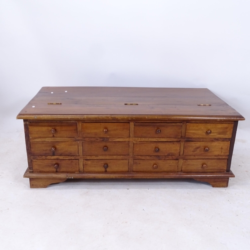 2211 - A hardwood centre-standing coffee table, with a rising lid and 12 short fitted drawers, W117cm, H44c... 