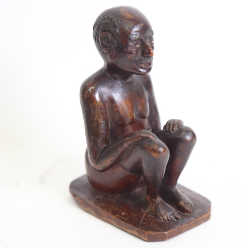 125 - An Indian 19th century wood carving of a seated man, height 9.5cm