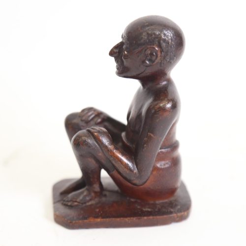 125 - An Indian 19th century wood carving of a seated man, height 9.5cm