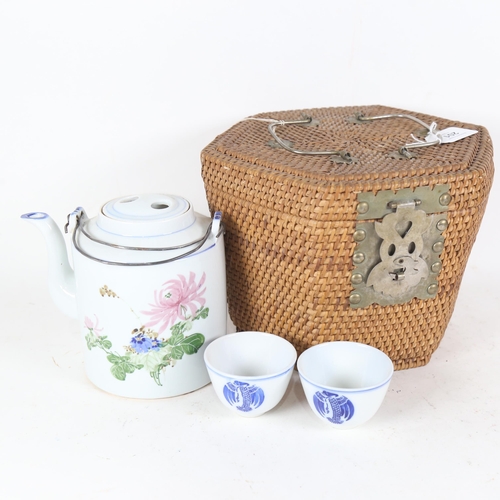 201 - A Vintage Japanese rattan-cased blue and white porcelain teapot and cup set