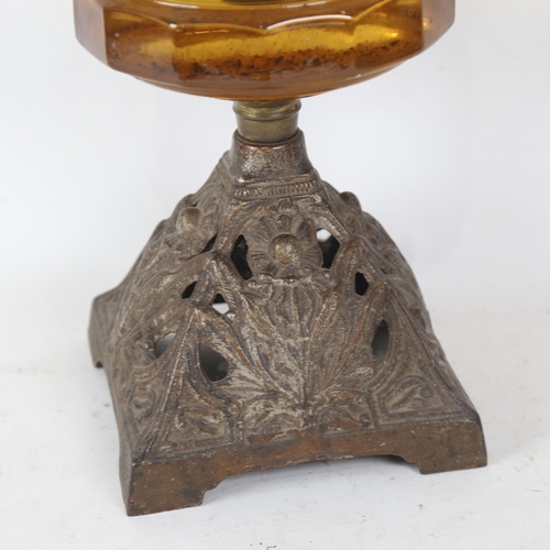 259 - An early 20th century brass oil lamp, with amber glass font and shade, overall height 55cm