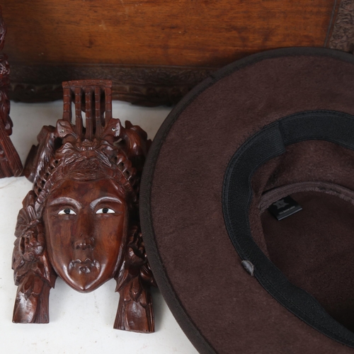 263 - Oriental carved hardwood tea tray, carved hardwood head ornaments, and a leather hat (4)