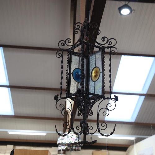 314 - A wrought-iron ceiling light fitting, with frosted and coloured glass panels, height 75cm (2 panels ... 