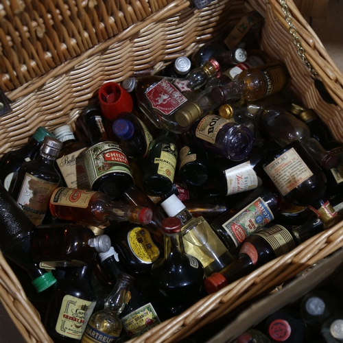 465 - A wicker hamper containing a quantity of miniature liquor bottles, including liqueurs and Whisky, an... 