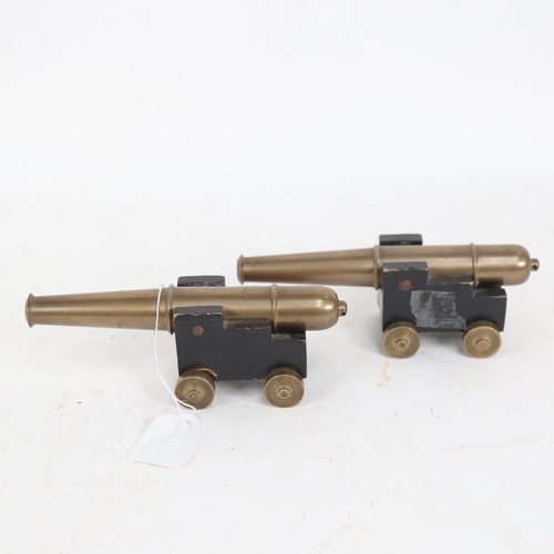 640 - A pair of bronze barrelled table cannons, on painted wood carriages with brass wheels, barrel length... 