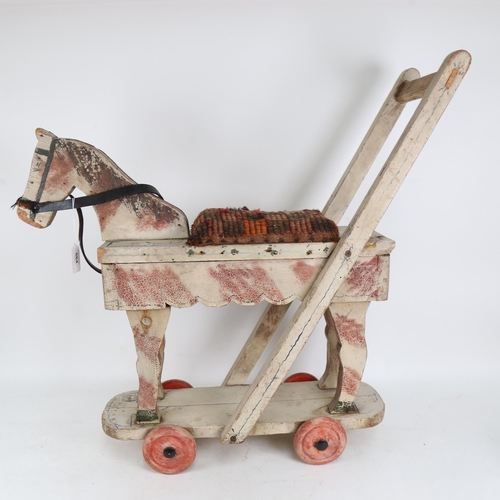 664 - A push-along painted wooden horse on wheels, height 66cm