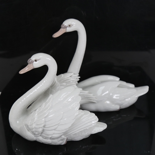 704 - 2 Lladro porcelain swan figures, model no. 5230 and 5231, largest height 21cm