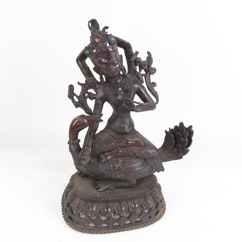 816 - Eastern bronze deity set with stones, seated on a duck, height 29cm