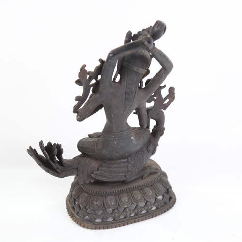 816 - Eastern bronze deity set with stones, seated on a duck, height 29cm