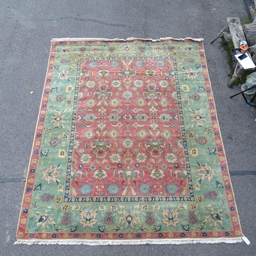 2732 - A red and green ground Persian design carpet, 350cm x 280cm. Viewing by appointment.