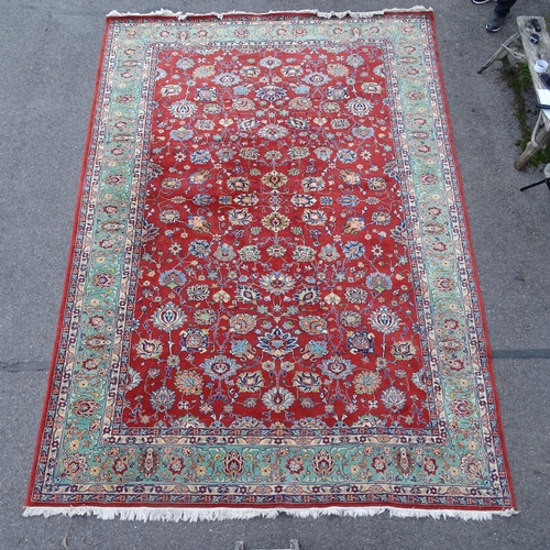 2738 - A red and green ground Persian design carpet, with floral symmetrical pattern, 423cm x 290cm. Viewin... 