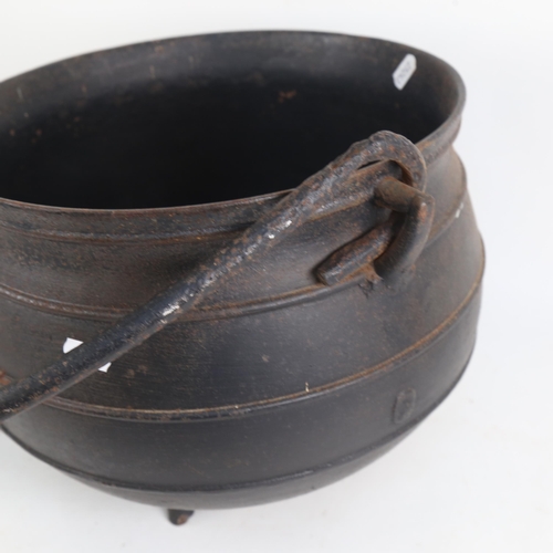 907 - A cast-iron cauldron, with carrying handle, overall width 38cm